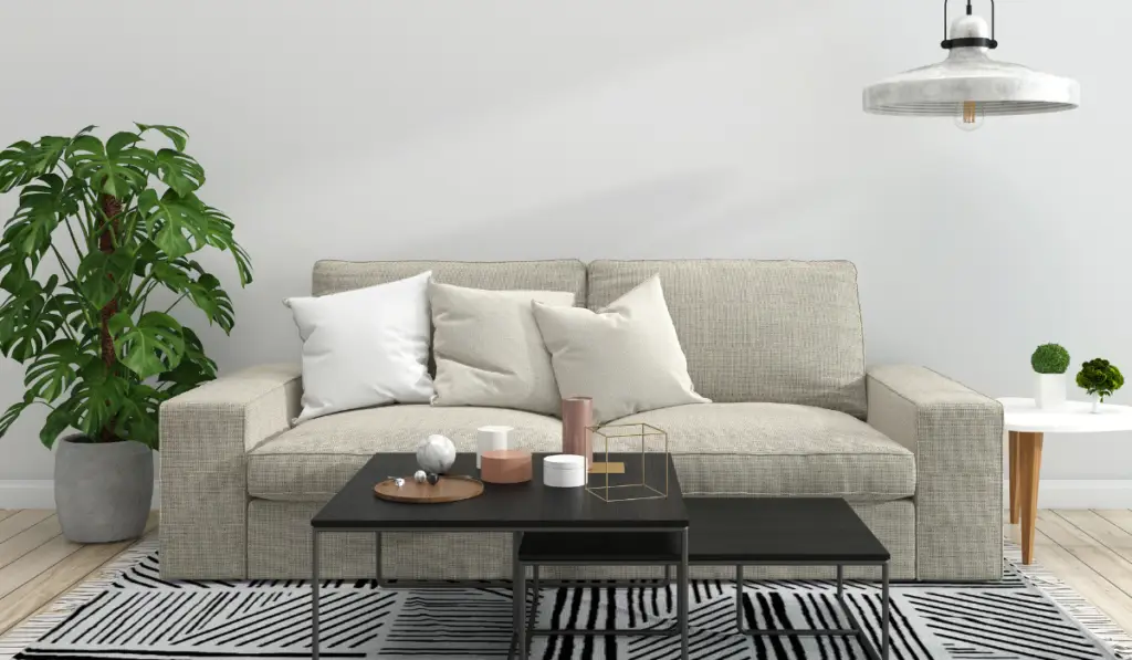Modern living room showcasing the importance of rugs in interior design with a stylish black and white patterned rug complementing a neutral-toned sofa and contemporary decor.